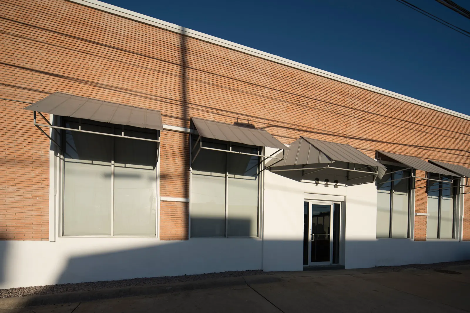 The building from the street: brick, steel awnings and a glass door.
